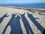 shadows of friends at the beach writing the wort LOVE